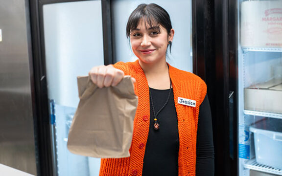 Woman holding brown lunch bag