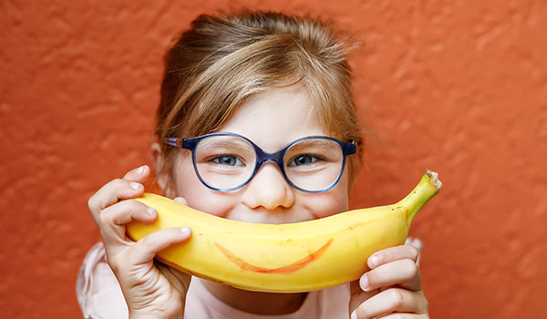 Child with banana and smiling face